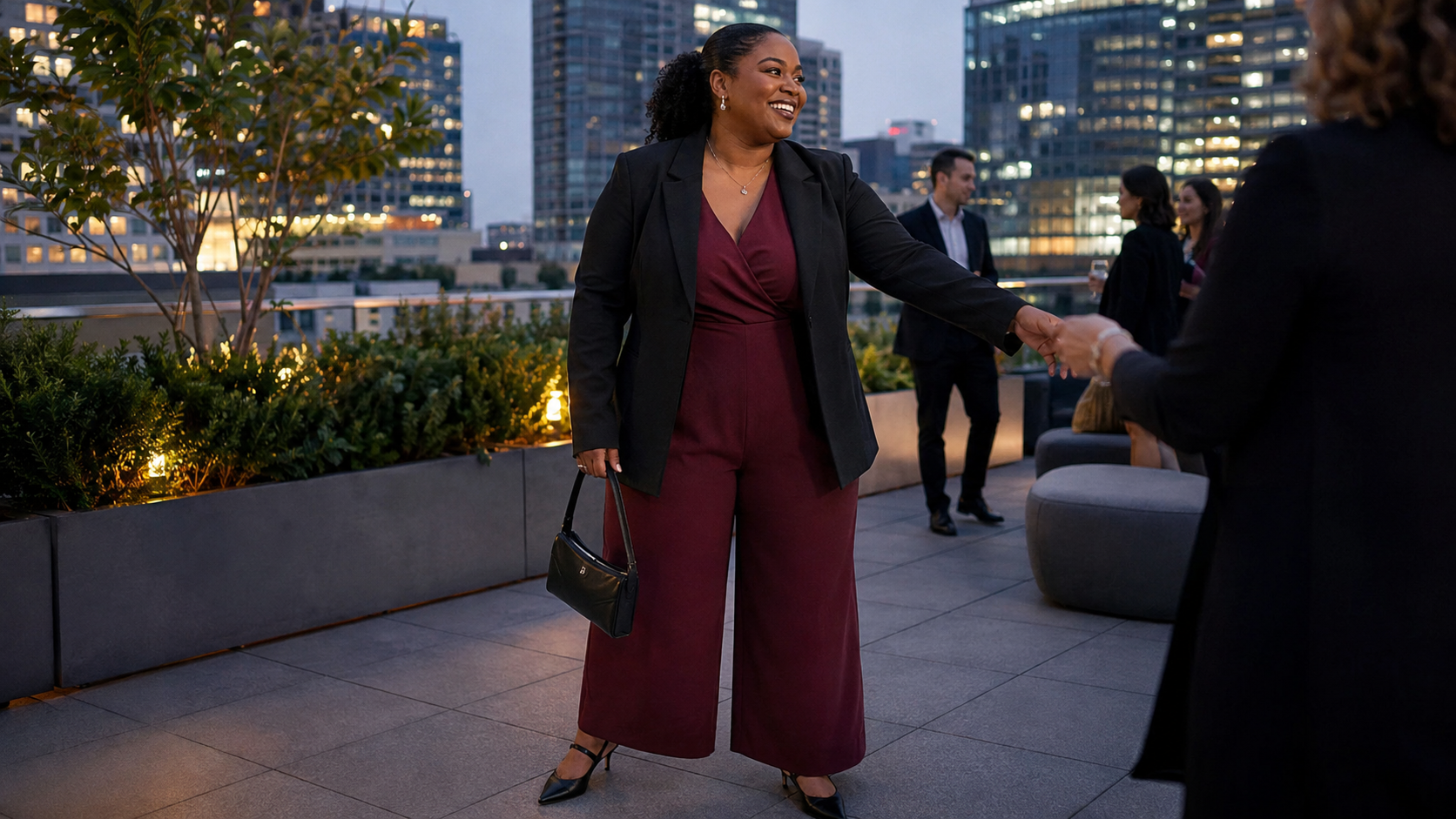 Woman wearing a burgundy wide-leg jumpsuit at an office rooftop party